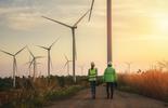 People walking along wind turbines 